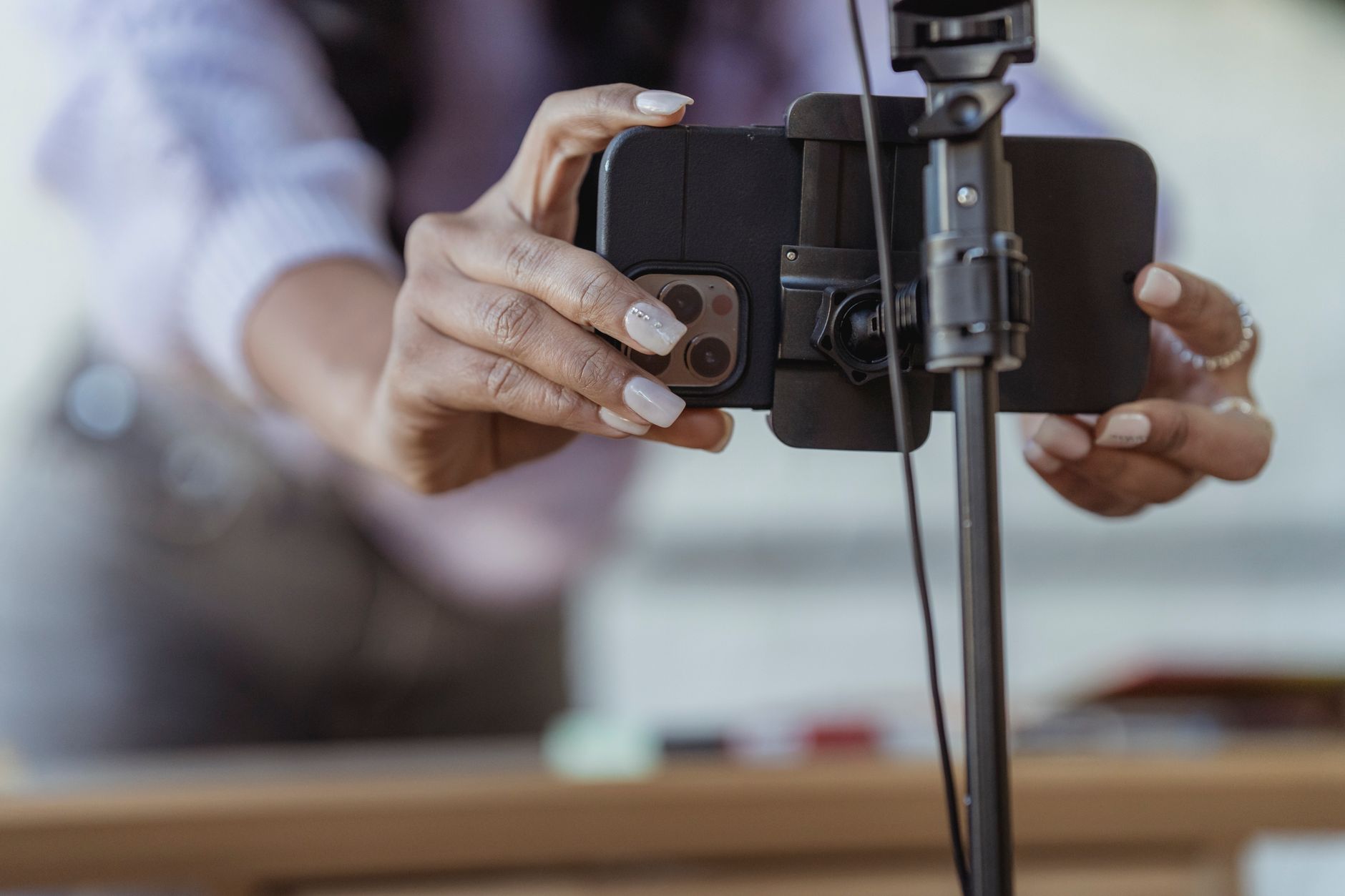 Personne installant un smartphone sur un trépied pour filmer une vidéo courte