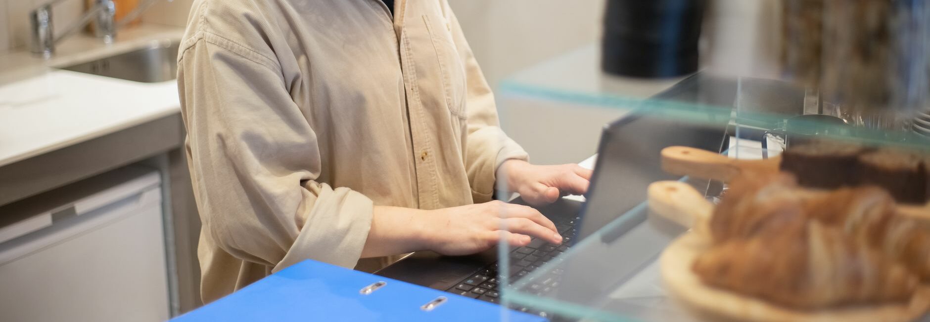 Commerçante devant son ordinateur portable derrière le comptoir de sa boutique