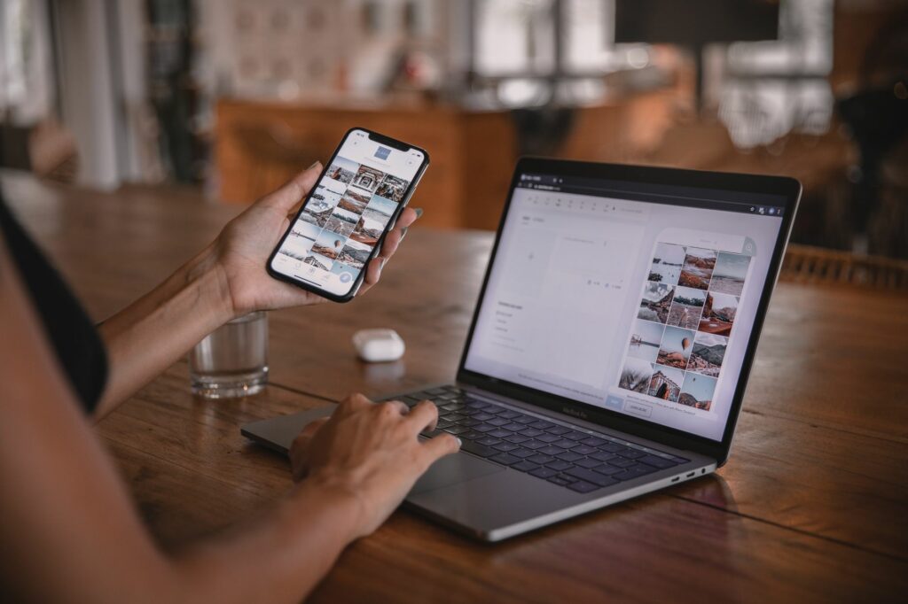 Une femme prépare des contenus pour les réseaux sociaux sur son smartphone et son ordinateur portable